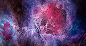 photo of a nebula with red, pink, purple an blue swirls