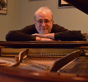 man leaning on a piano