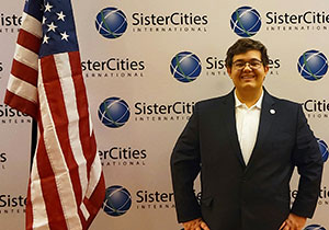 man posing beside an American flag