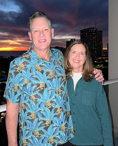 man and woman on a balcony at sunset