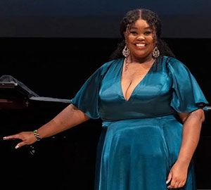 woman standing with on hand on a piano