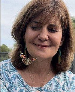 head photo of a woman admiring a moth flying in front of her