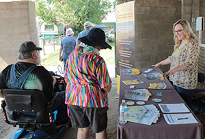 woman presenting materials on at table to onlookers