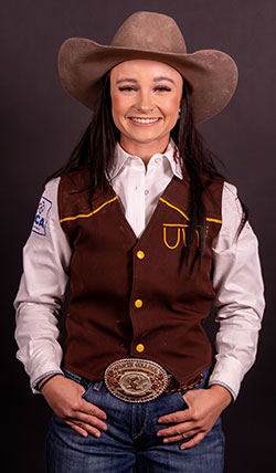 woman posing in western wear including a big rodeo belt buckle