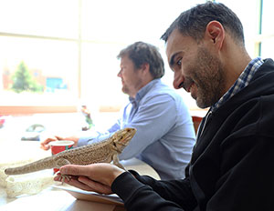 man looking at a large lizard in his hands