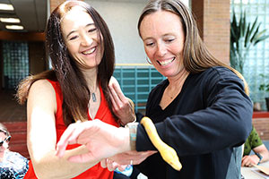 two people with a pale yellow snake
