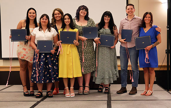 group of people displaying diploma holders