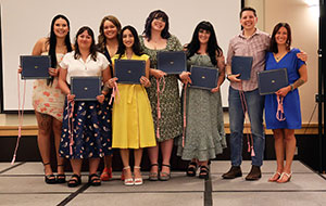 group of people posing for this photo and holding diploma folders