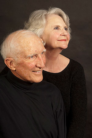 man and woman posing against a black background