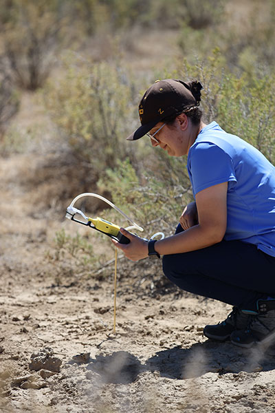 woman using device in a field area