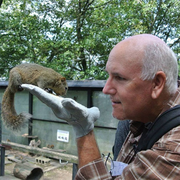 man feeding a squirrel on his hand