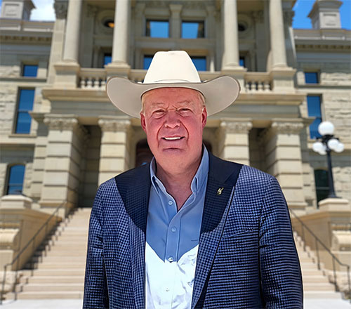 man standing in front of the steps of a large building