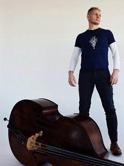 man standing with a bass lying on the floor in front of him