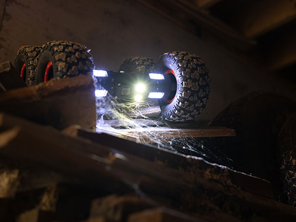 car-style robot with big wheels and bright lights on it