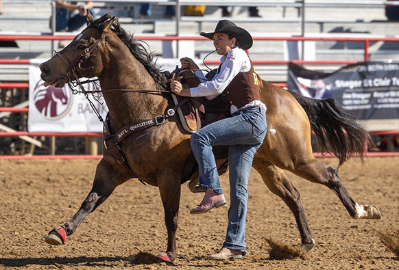 woman dismounting a horse as it is moving