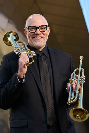 man holding two trumpets
