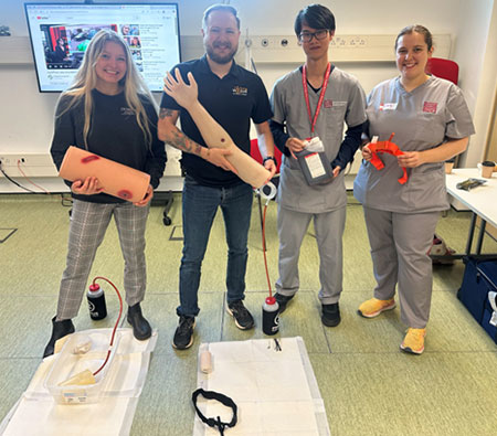 four people holding medical training equipment