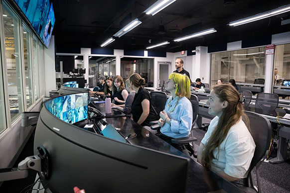 women seated at control room consoles