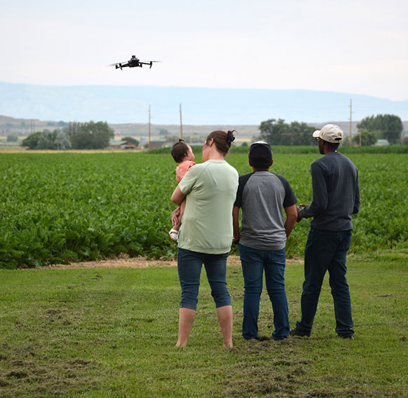 people watching a drone over a field