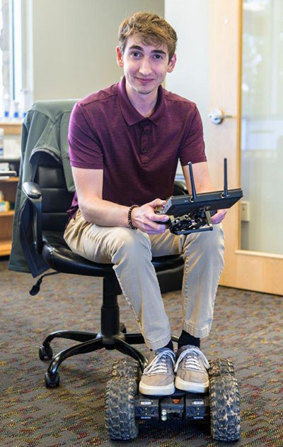 man with a remote controller and his feet on a remote-controlled vehicle
