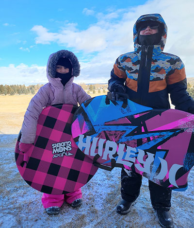 children holding sleds