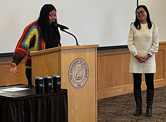 person at a podium with a person standing nearby