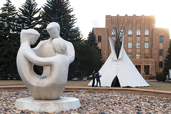 tipi with a statue in the foreground