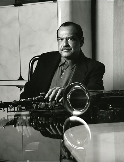 man with a saxophone on a table in front of him