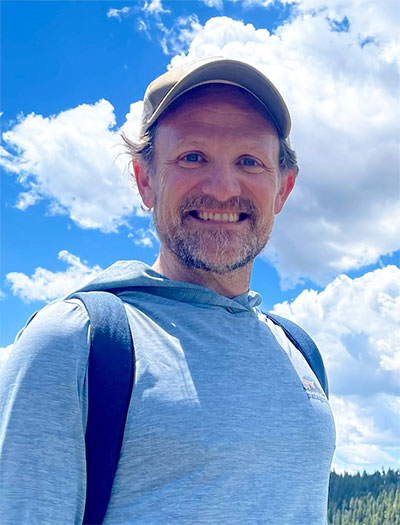man standing outside in the mountains