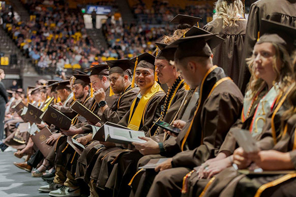 students in caps and gowns seated in rows