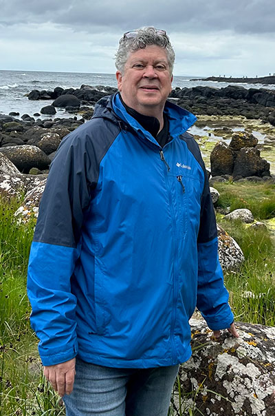 man standing outside near a rocky shore