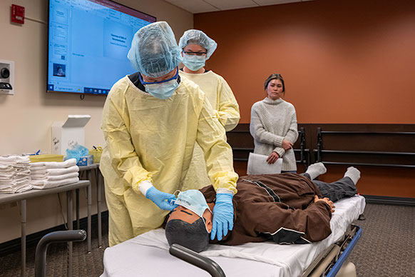people with a manikin on a bed