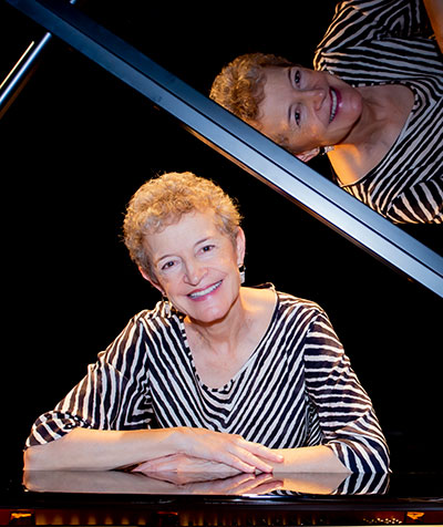 woman sitting at a grand piano