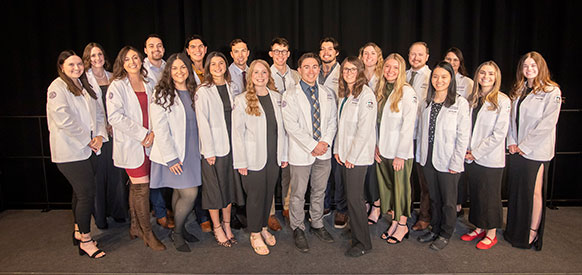 group of people posing in white coats