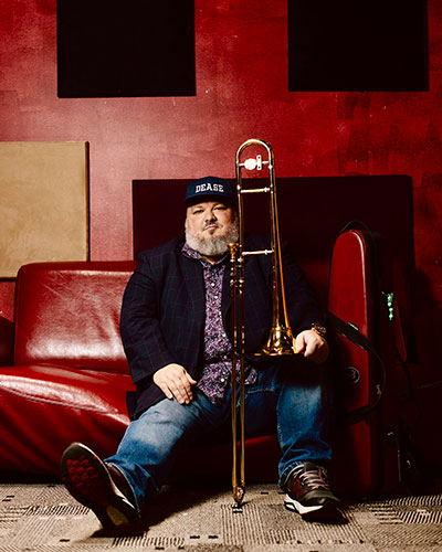 man sitting down holding a trombone