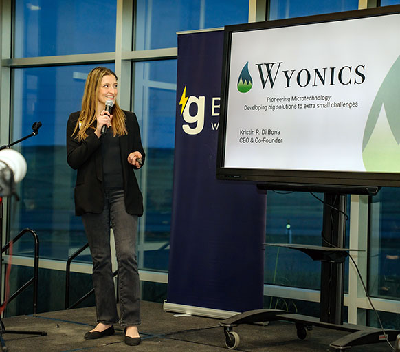 woman speaking with a screen display behind her