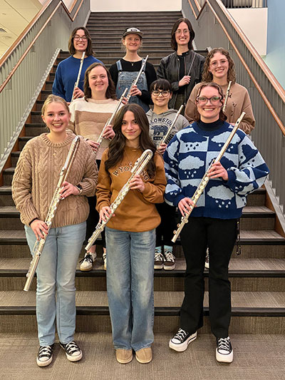 group of people holding flutes while standing on stairs