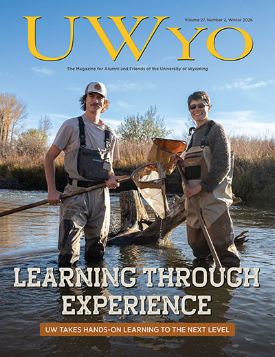 magazine cover featuring two people wearing waders in water