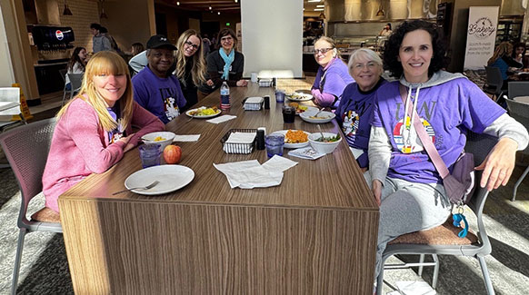 group of people sitting at a table eating