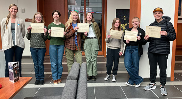 students holding up certificates
