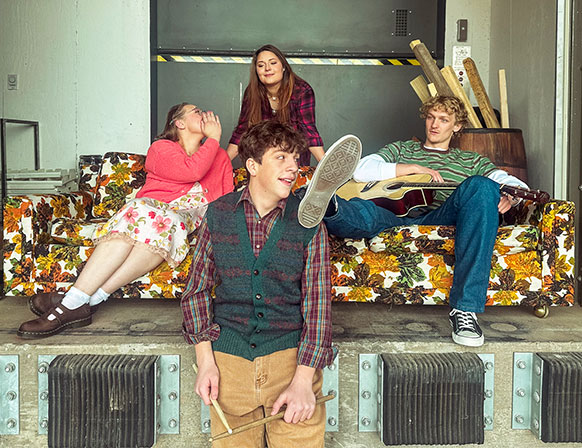 four people posing on a theater set