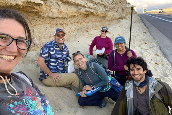 group of people posing together on the side of a road