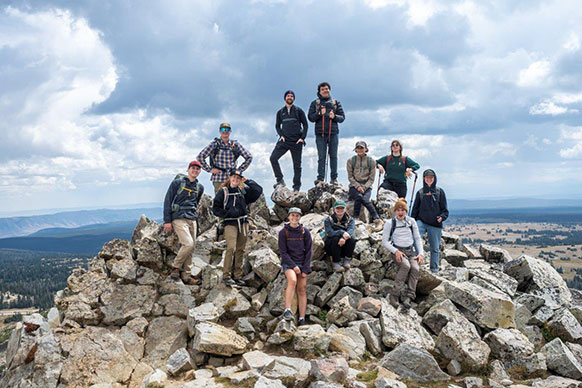people posing on a large pile of boulders