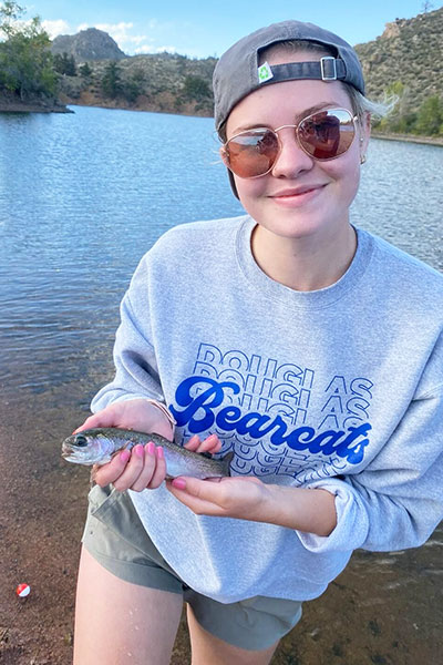 woman smiling and holding a fish