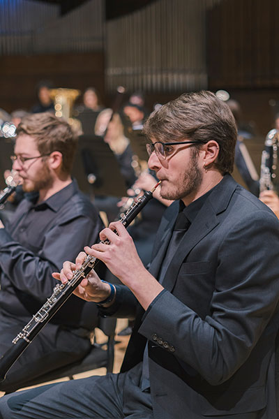 man playing an oboe in a band