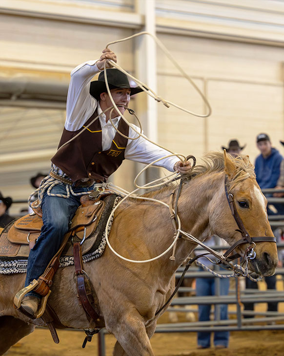 man on a horse twirling a rope