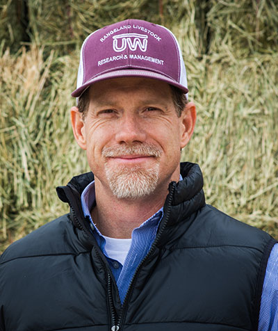 man standing in front of hay bales