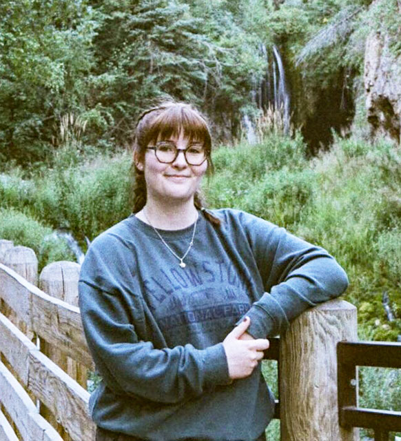 woman leaning on a post outside