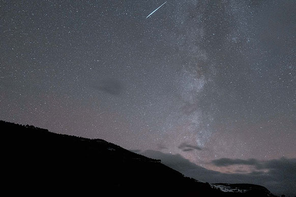 shooting star over a hilltop