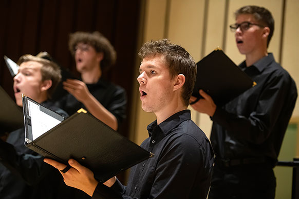 people holding folders up and singing